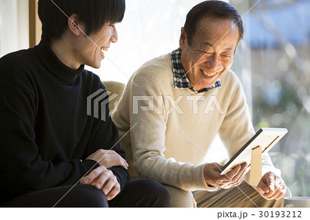 祖父と写真を見る孫 30193212