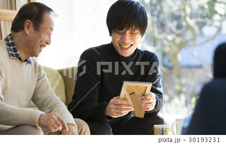 祖父と写真を見る孫 30193231