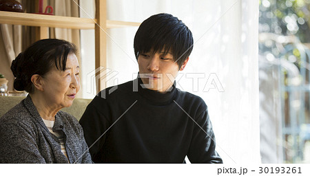 祖母と写真を見る孫 30193261