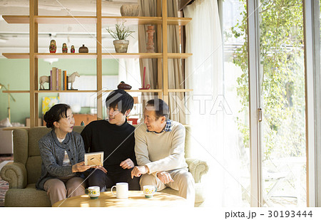 祖父母と写真を見る孫 祖父母と写真を見る孫 30193444