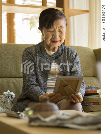 引っ越し作業　写真を見るシニア女性　 30193474
