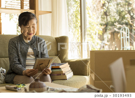 引っ越し作業　写真を見るシニア女性　 30193493