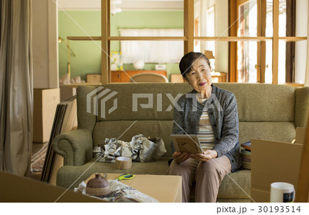 引っ越し作業 写真を見るシニア女性 引っ越し作業 写真を見るシニア女性 30193514