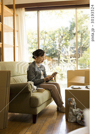 引っ越し作業 写真を見るシニア女性 引っ越し作業 写真を見るシニア女性 30193524