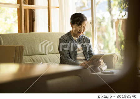 引っ越し作業 写真を見るシニア女性 引っ越し作業 写真を見るシニア女性 30193540