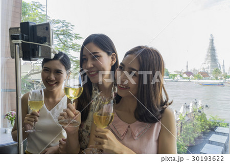 Ladies are taking selfie near temple in a restaurant in Bangkok 30193622