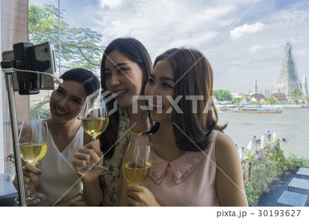 Ladies are taking selfie with temple background in a bangkok's restaurant 30193627