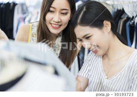 Young girls look very delighted while choosing clothes Young girls look very delighted while choosing clothes 30193723