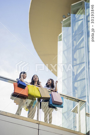 a group of women are standing in the glass balcony. 30193846