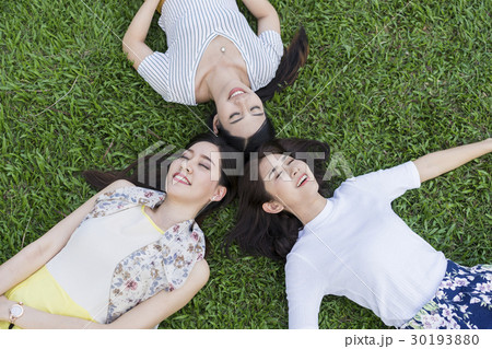 A group of friends is relaxing on the grass in the park. 30193880