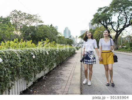 Photo of two Asian girl hand in hand in the street. 30193904