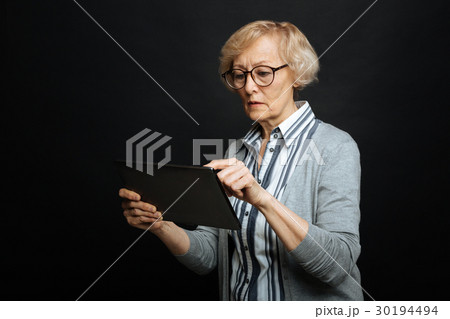 Involved retired woman using tablet in the studio 30194494