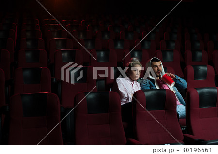 Young romantic couple watching movie in theater Young romantic couple watching movie in theater 30196661