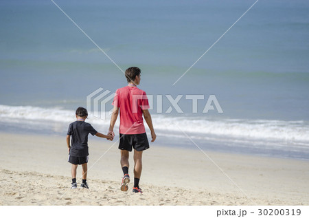 father and son walking and holding hands 30200319