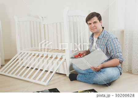 Young man assembling furniture by himself 30200628