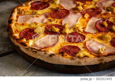 Pizza with ham, sausages and chicken on wood  30201405