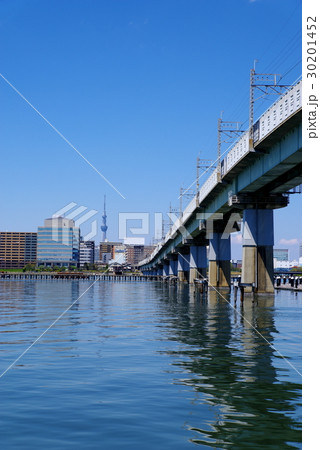 東京の水辺と鉄道橋 JR砂町運河橋梁とビル越しの東京スカイツリー 中望遠 タテ 東京の水辺と鉄道橋 JR砂町運河橋梁とビル越しの東京スカイツリー 中望遠 タテ 30201452