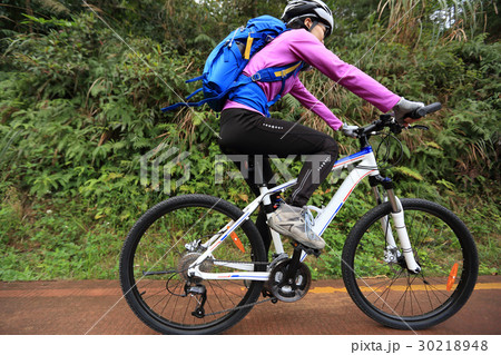 young woman riding mountain bike on forest trail 30218948