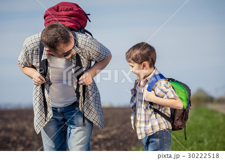 Father and son walking on the road at the day time. 30222518