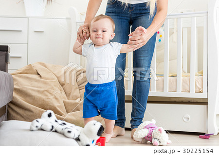 Cute baby learning how to walk with mother at home Cute baby learning how to walk with mother at home 30225154