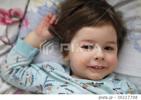 Portrait of a young child lying on a pillow Portrait of a young child lying on a pillow 30227708