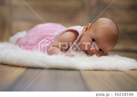 Newborn cute baby lying on white fur skin Newborn cute baby lying on white fur skin 30228596