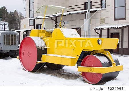 Yellow retro road roller at the winter landscape. 30249954