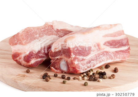 pieces of pork with peppercorn on a cutting board 30250779