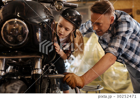 Sweet fascinated child examining shiny details of Sweet fascinated child examining shiny details of 30252471