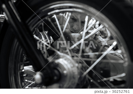 Excellent master mechanic repairing a wheel Excellent master mechanic repairing a wheel 30252761