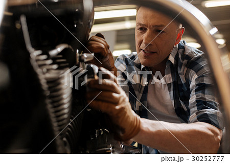 Experienced local mechanic enjoying his work Experienced local mechanic enjoying his work 30252777