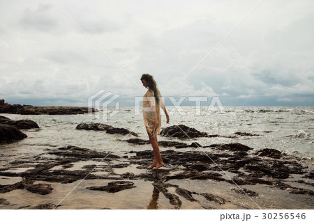 beautiful girl stands in the water on the beach 30256546