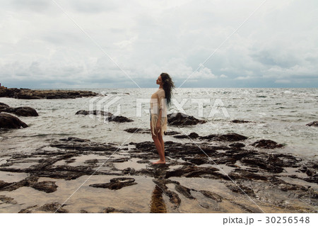 beautiful girl stands in the water on the beach 30256548