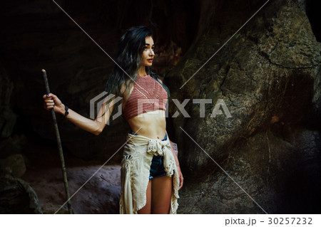Young girl on the background of an old cave. The 30257232