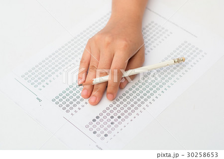 woman's hands filling in standardized test form 30258653