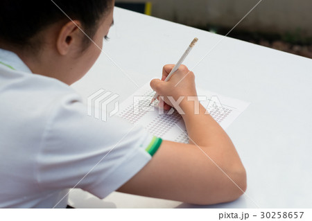 Student filling out answers to a test with pencil 30258657