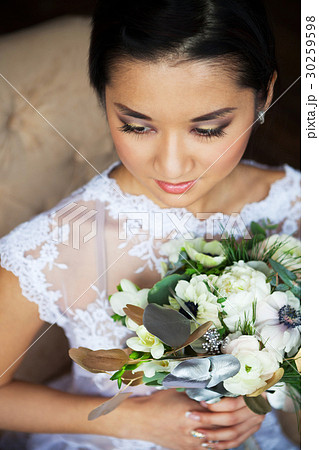Bride holding wedding bouquet with ranunculus 30259598
