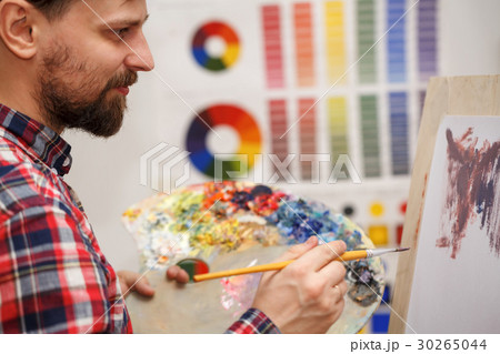 Artist paints with oil paints 30265044
