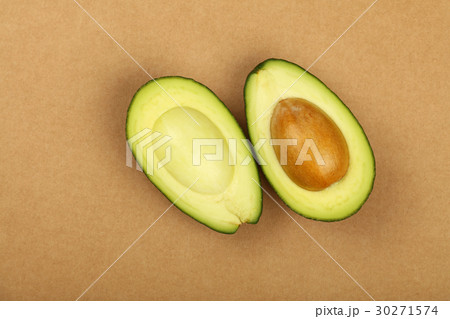 Two halves of avocado on brown paper parchment Two halves of avocado on brown paper parchment 30271574