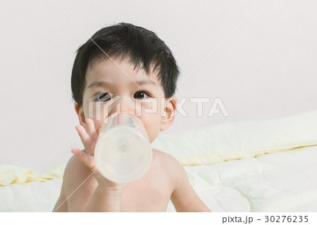 Baby Boy on the Couch is Eating the Milk from the Bottle with sp 30276235