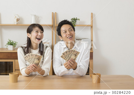 お金を持っていろいろ想像をする夫婦 30284220