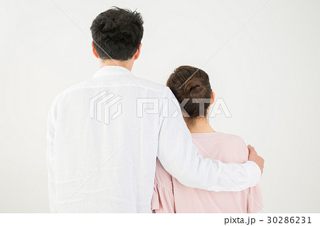 肩を抱く男女の後ろ姿の写真素材
