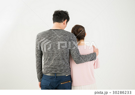 肩を抱く男女の後ろ姿の写真素材