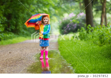 Child playing in the rain with umbrella 30297852