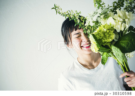 花と笑顔の女性 ポートレートの写真素材