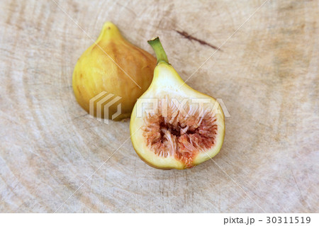 Fig cut open showing the flesh wooden background. Fig cut open showing the flesh wooden background. 30311519