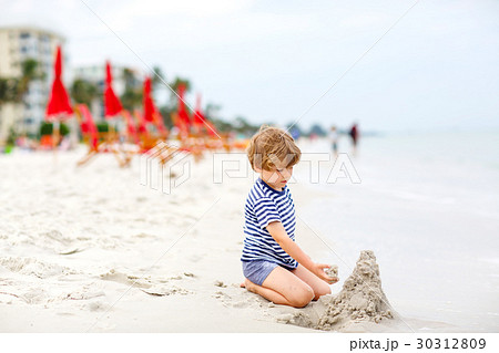 Little kid boy having fun with building sand Little kid boy having fun with building sand 30312809