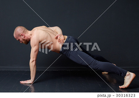 Young man is doing push-ups on one hand Young man is doing push-ups on one hand 30316323