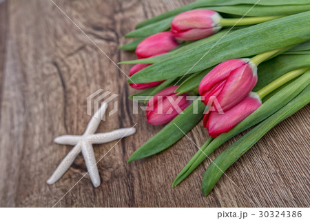 Starfish and tulips on a wooden background 30324386