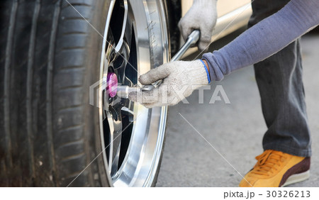 Auto mechanic changing racing car wheel 30326213